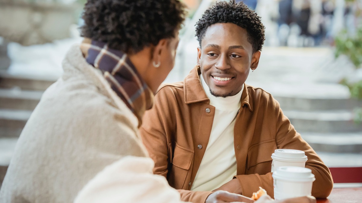 Couple smiling and talking over coffee during a relaxed conversation
