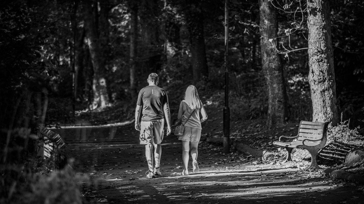 Couple walking together on a wooded path, representing connection and shared choice