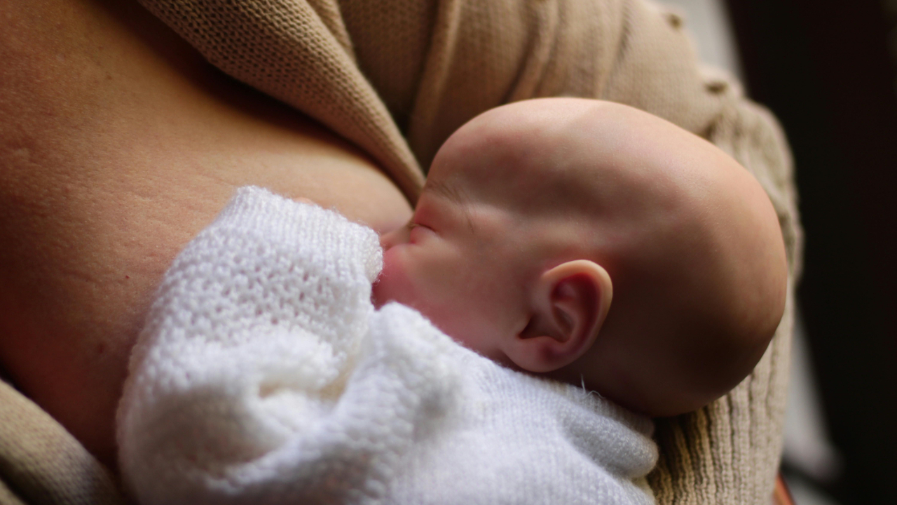 Mother breastfeeding her baby while sitting
