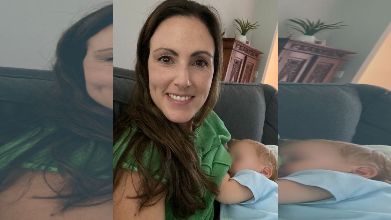 Mother breastfeeding her baby while sitting on a couch at home