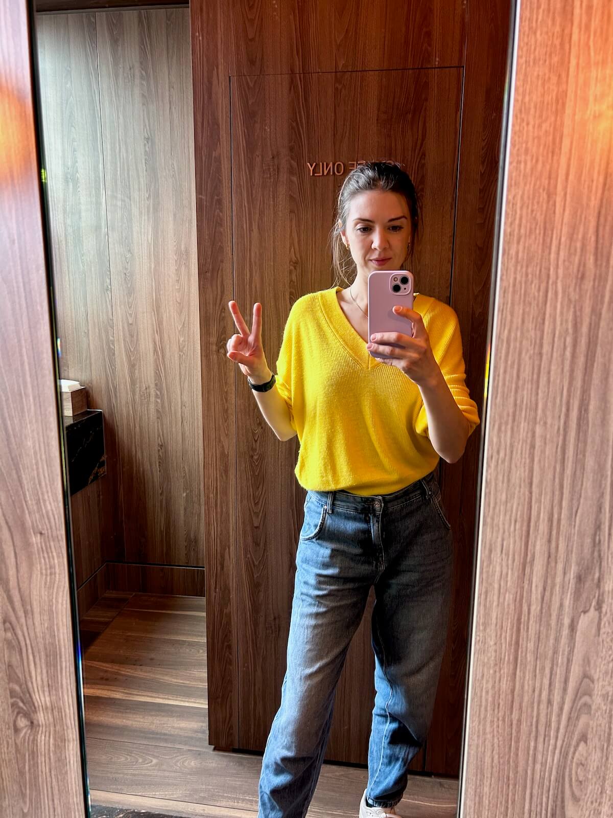Amy Lord, coach for creative female founders, taking a mirror selfie in a yellow jumper