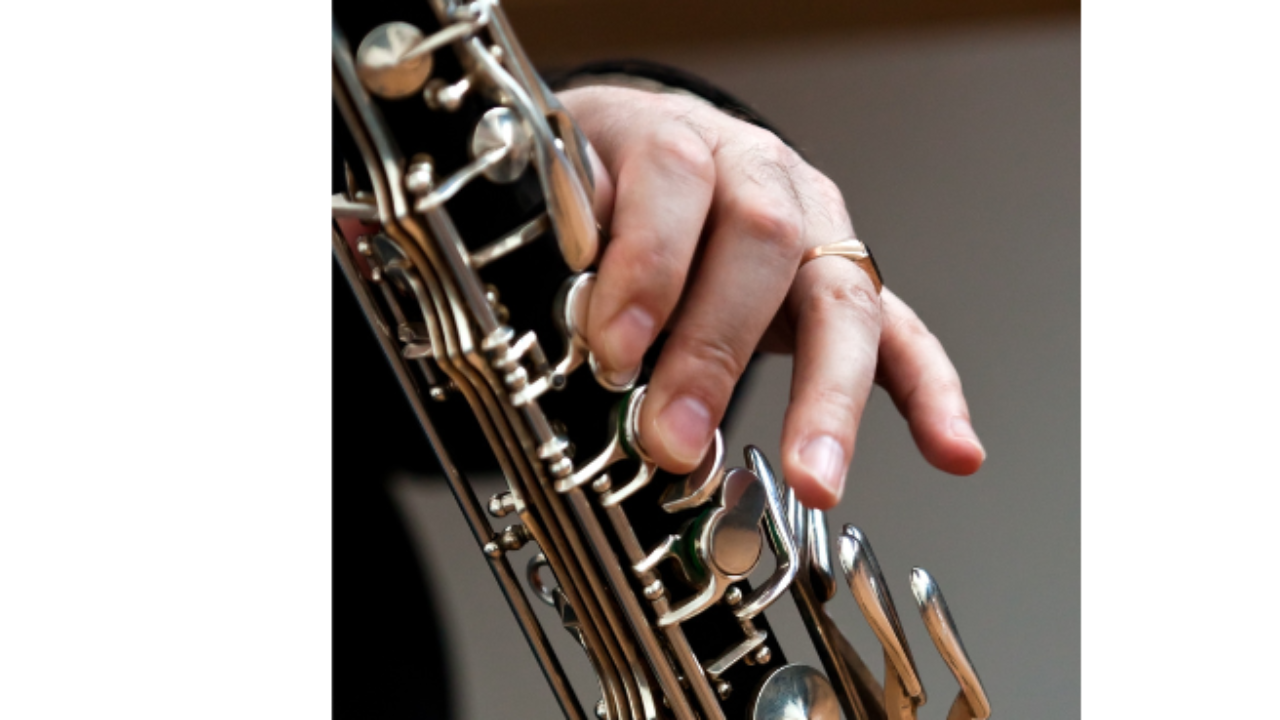 A hand demonstrating fingerings on the bass clarinet