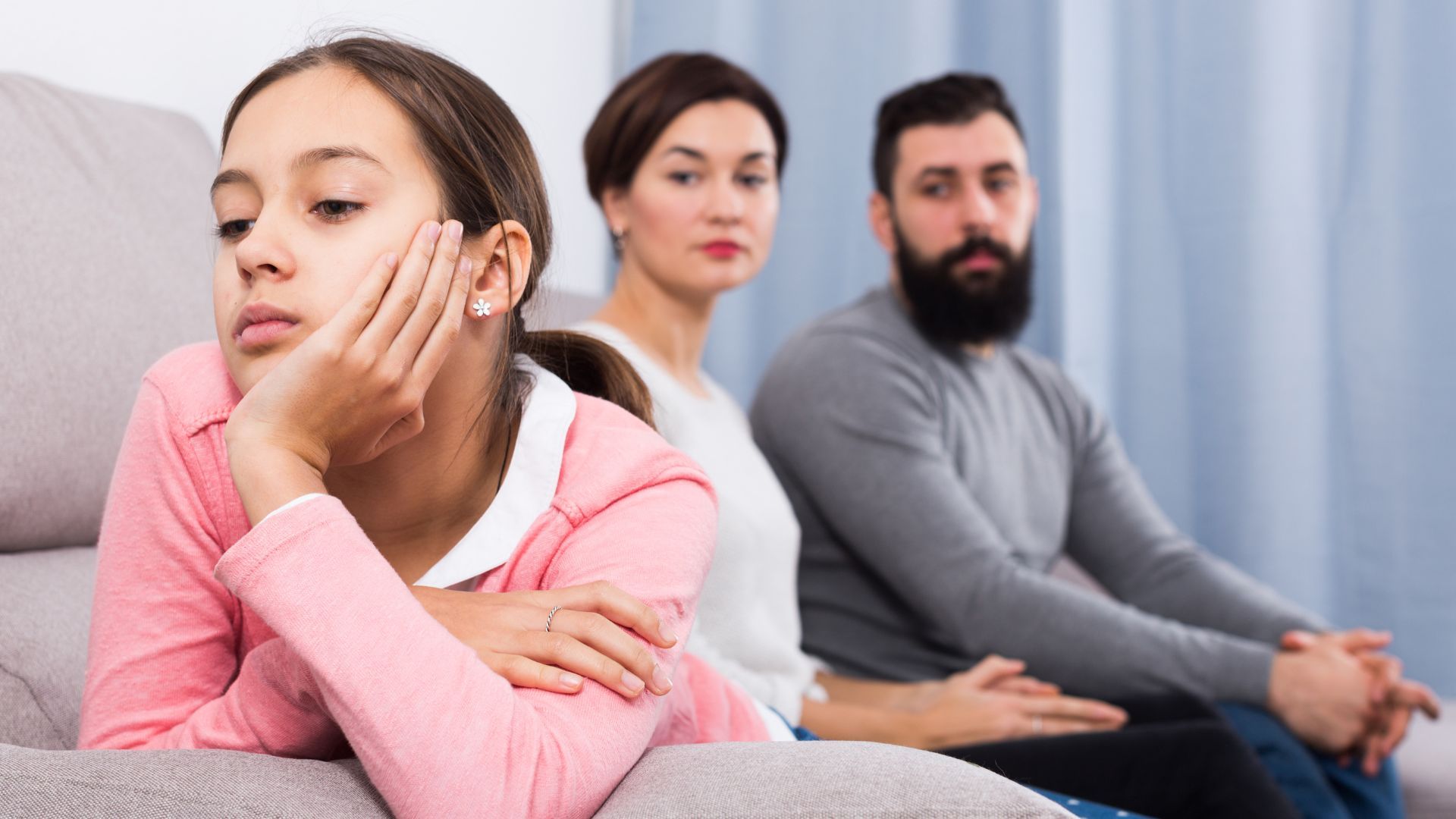 Parent sitting across from teen with a written list of house rules—representing clear, consistent boundaries at home.