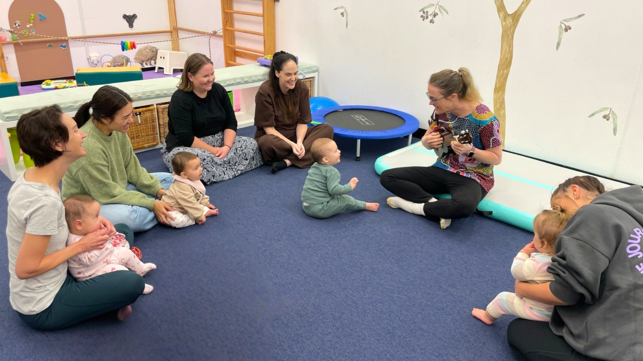 Parents and babies enjoying interactive play at baby playgroup.