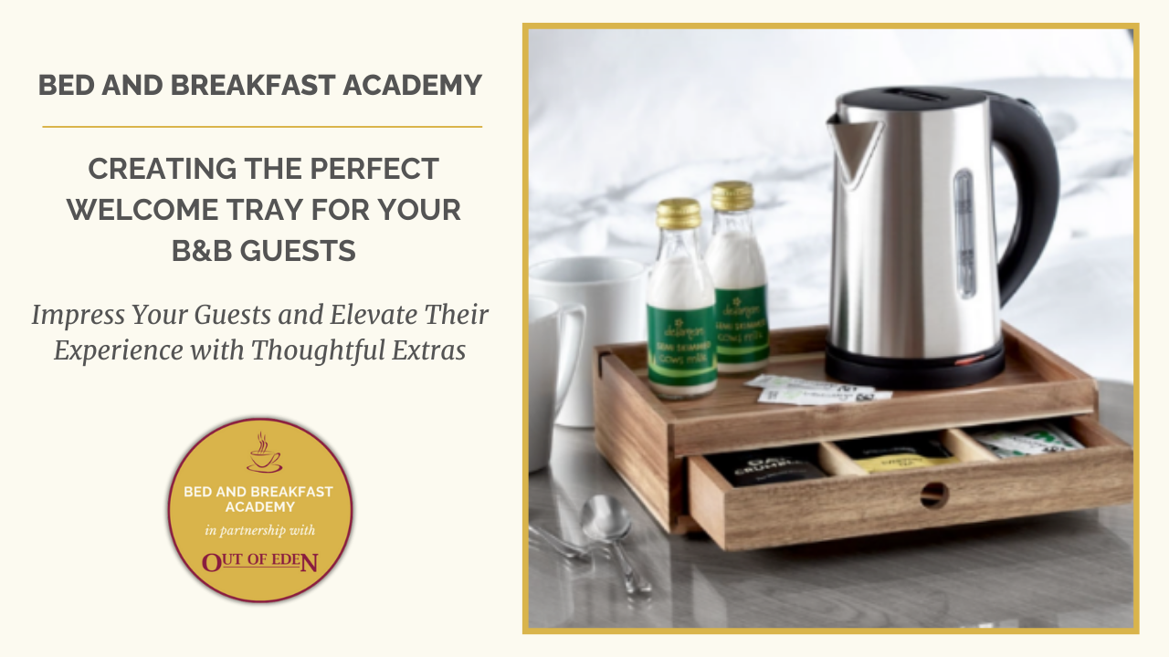 Image featuring a promotional graphic for Bed and Breakfast Academy. On the left, text reads: 'Creating the Perfect Welcome Tray for Your B&B Guests' and 'Impress Your Guests and Elevate Their Experience with Thoughtful Extras.' Below the text is a logo for Bed and Breakfast Academy in partnership with Out of Eden. On the right, a photo shows a neatly arranged wooden welcome tray containing a stainless steel kettle, bottles of milk, mugs, tea bags, and other refreshments, placed on a bed