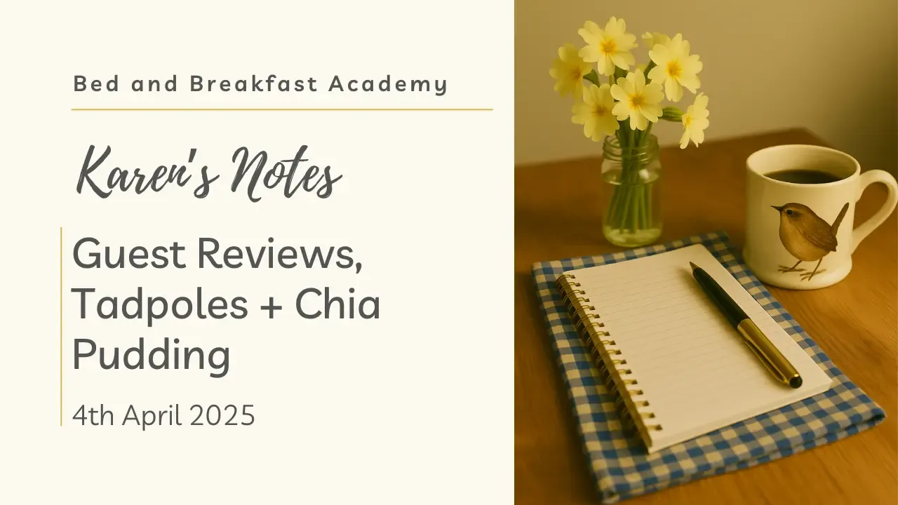 A cosy tabletop scene with a jar of primroses, a cream mug featuring a wren, and a spiral notebook with a pen, resting on a blue check napkin. Styled in warm natural light for Karen’s Notes from the Bed and Breakfast Academy, dated 4th April 2025.