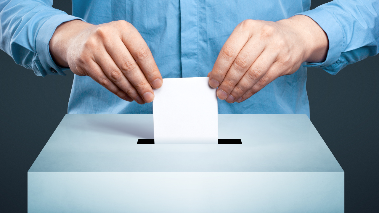 man casting vote in ballot box