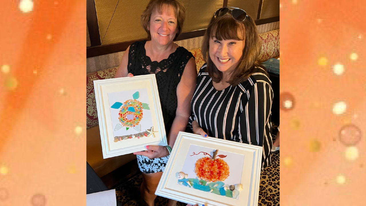 Two guests smiling with their fall beach glass pumpkin and turtle art at a Cleveland paint and sip party