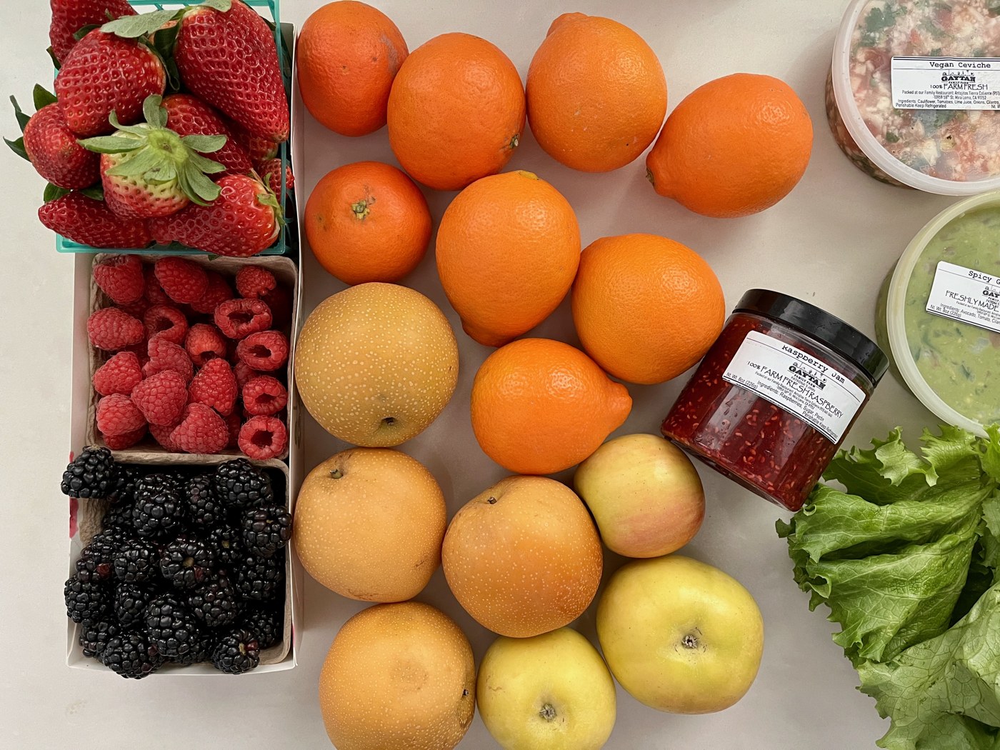 A farmers’ market haul with strawberries, raspberries, blackberries, citrus, apples, and pears