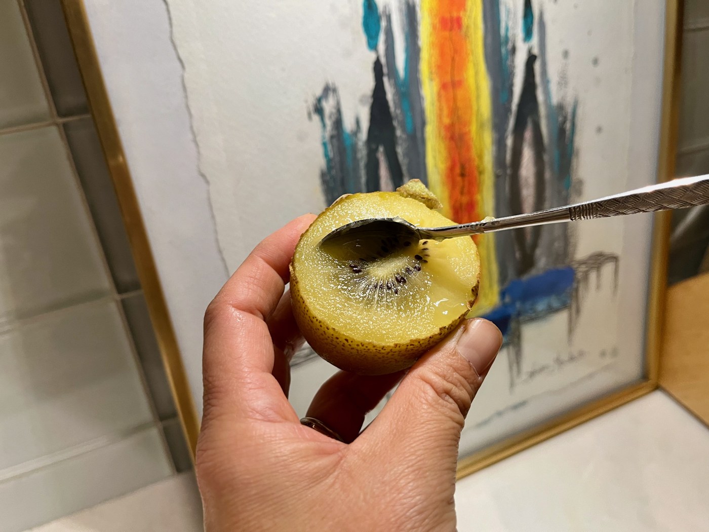 A golden kiwifruit cut in half and eaten straight from its skin with a spoon
