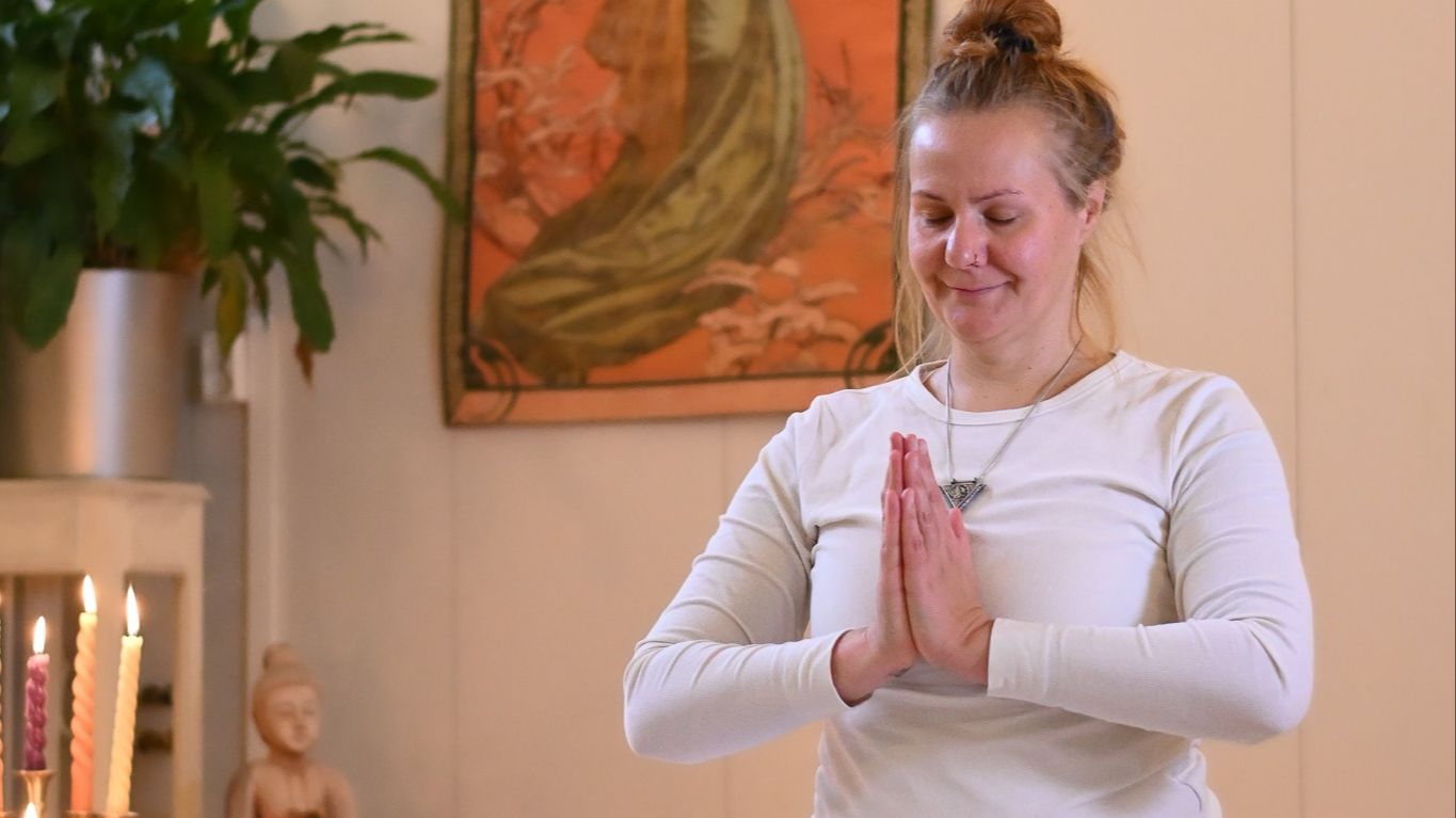 “Nainen joogaa rauhallisessa asennossa, hengitys ja kehotietoisuus tukemassa vaihdevuosien hyvinvointia ja hermoston rauhoittumista.”