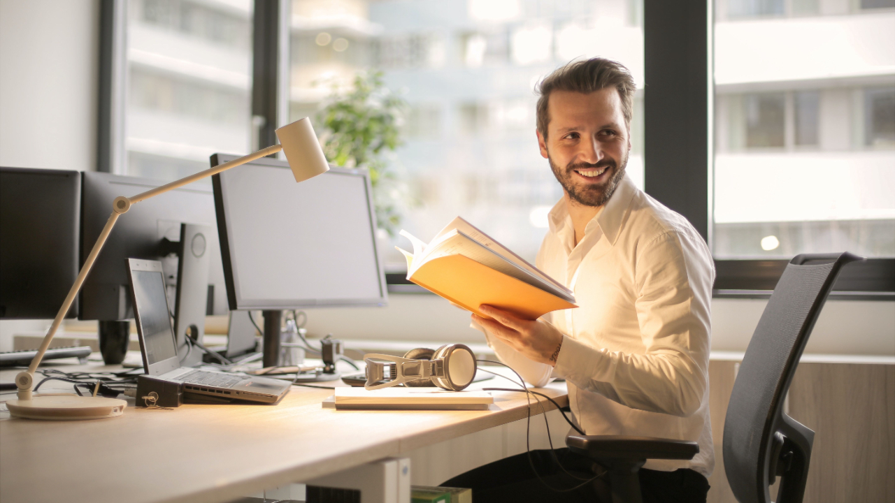 man sitting at desk smiling