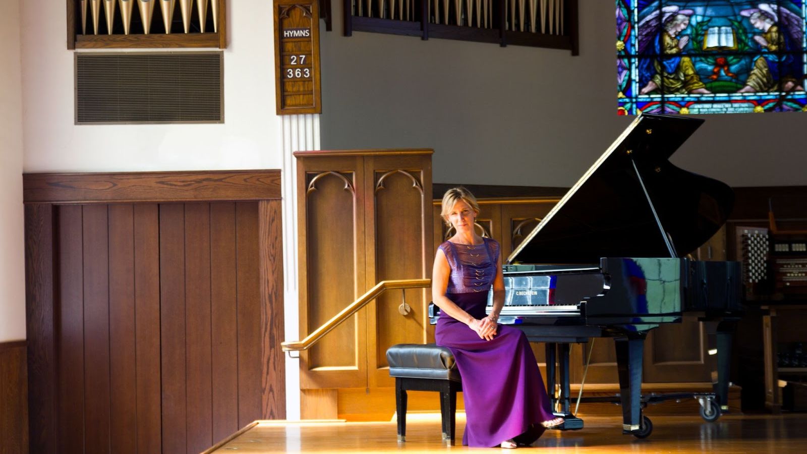 Molly Forde Knight sitting at piano in cathedral