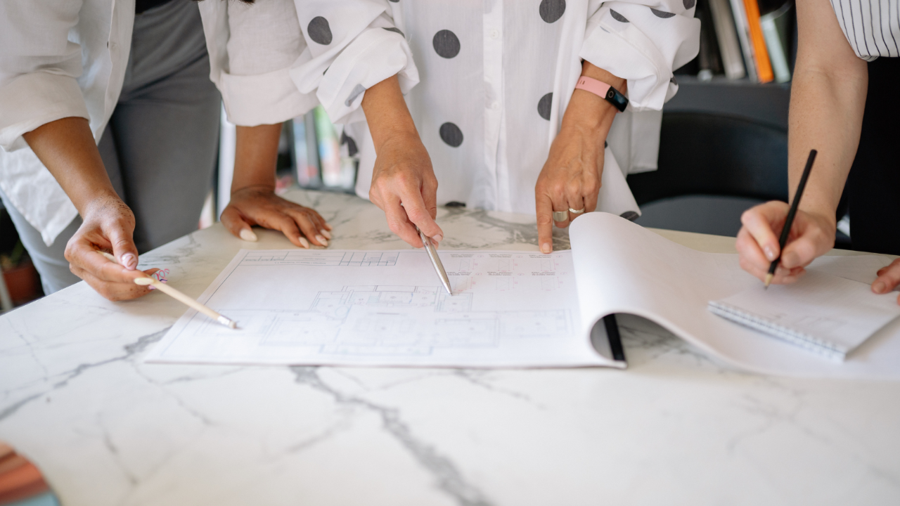 Workplace meeting table showing collaboration and conversation amongst 3 team members