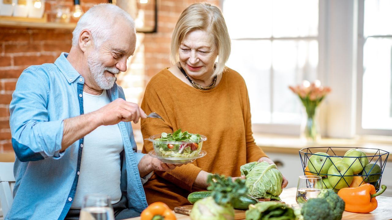 Older couple in kitchen with vegetables