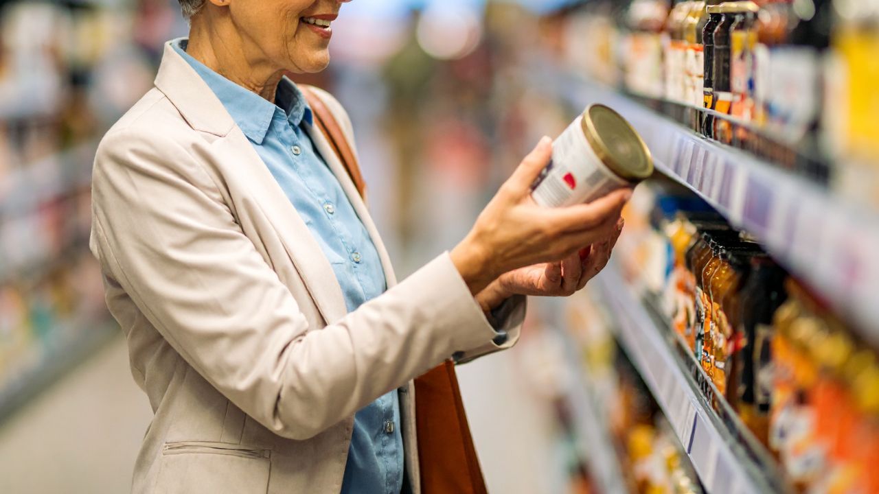 woman reading a label on a can, plant-based health  