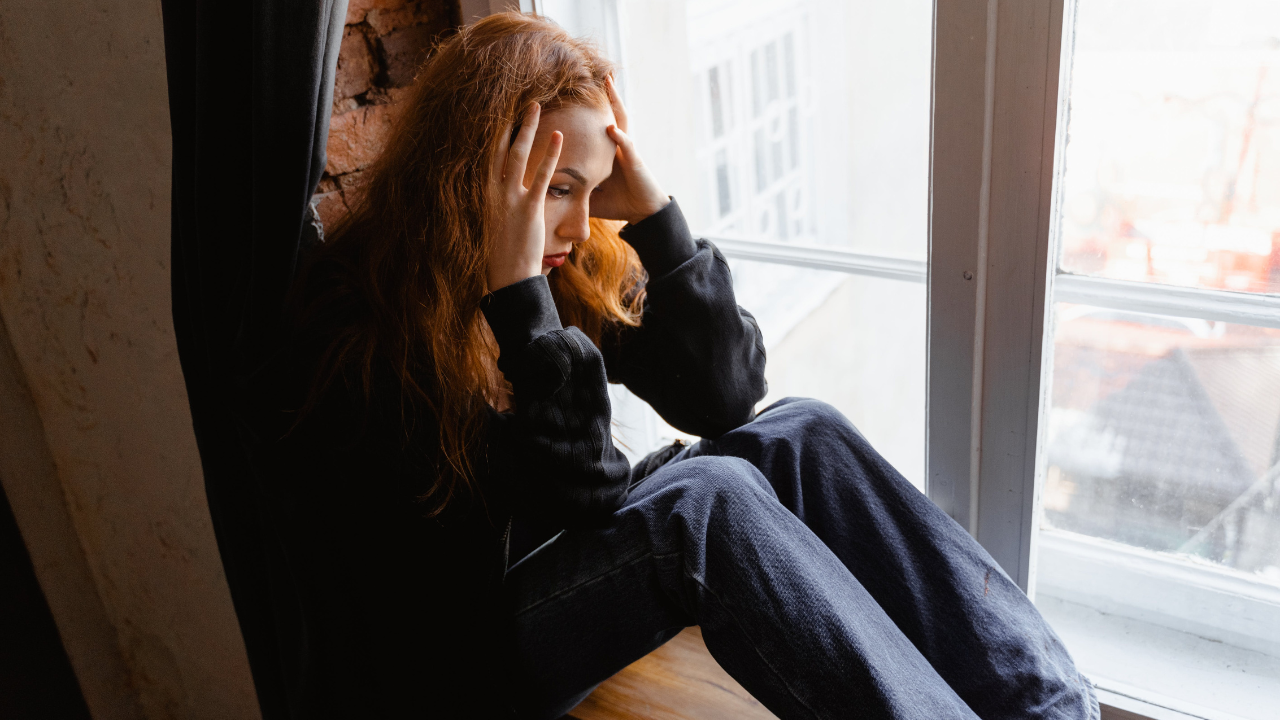 woman trying to regulate her nervous system while looking out the window