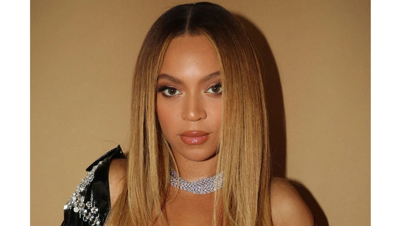 Beyonc&eacute posing in front of a golden background