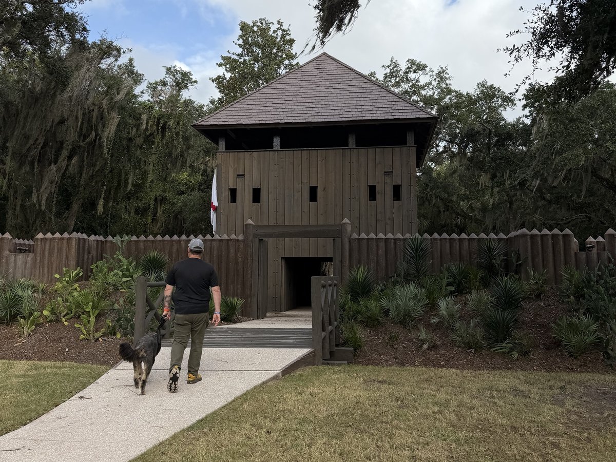 Walking a doodle toward the reconstructed fort at Fort Mose Historic State Park