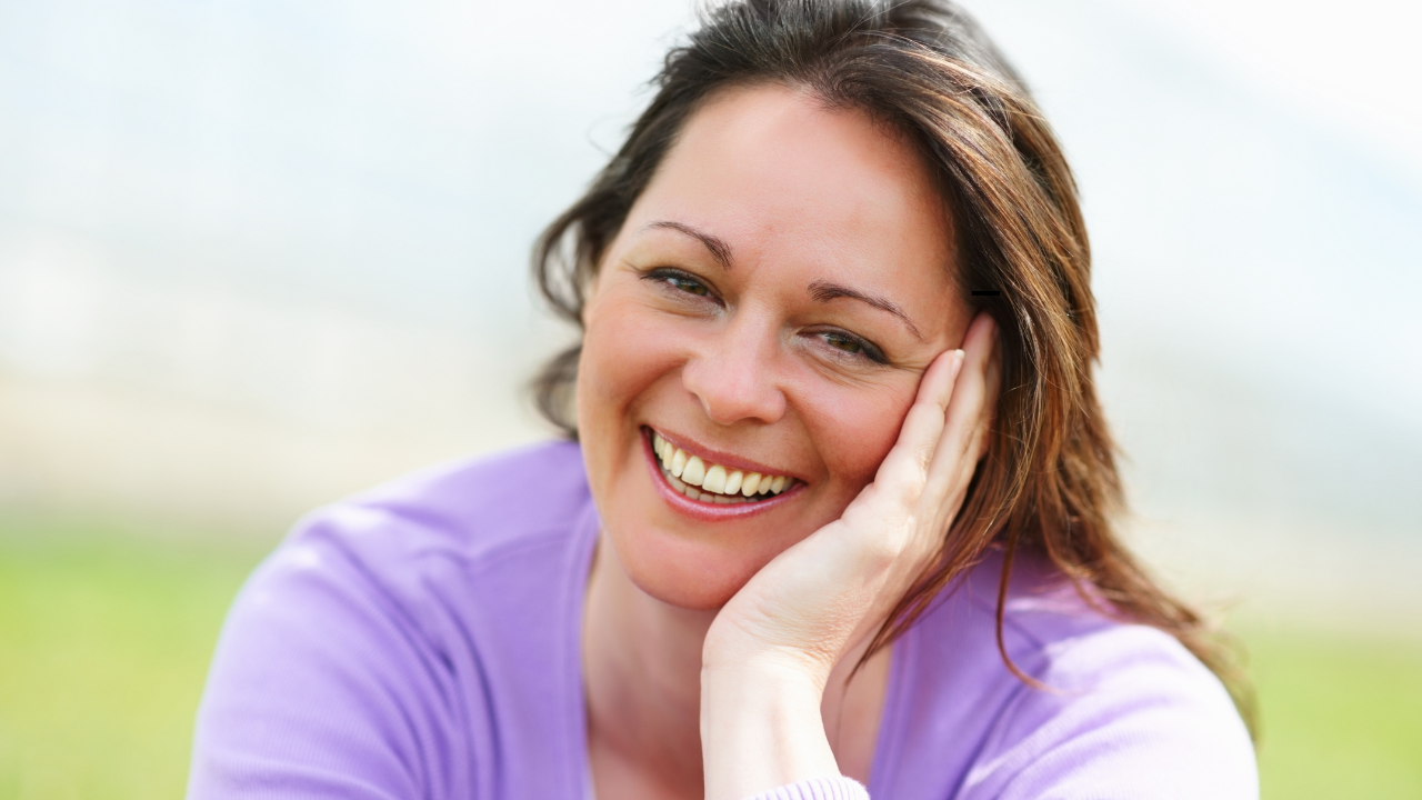 Happy woman in grassy field.
