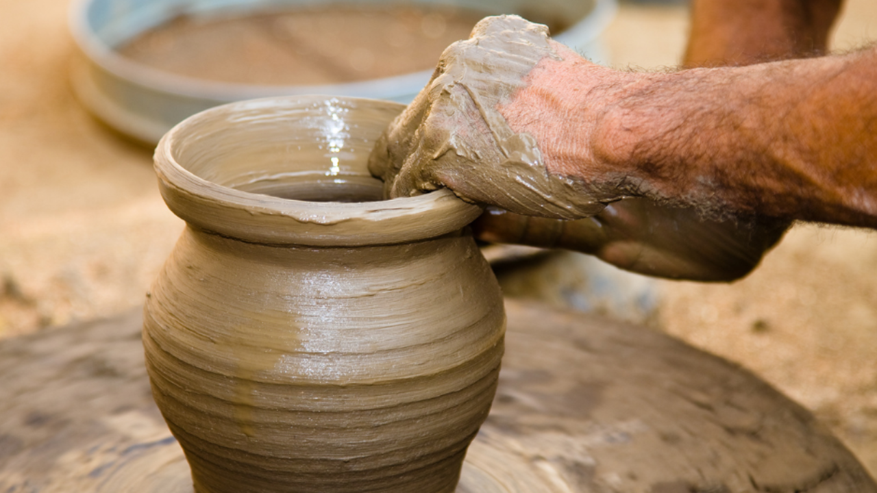 A potter shaping a clay pot.