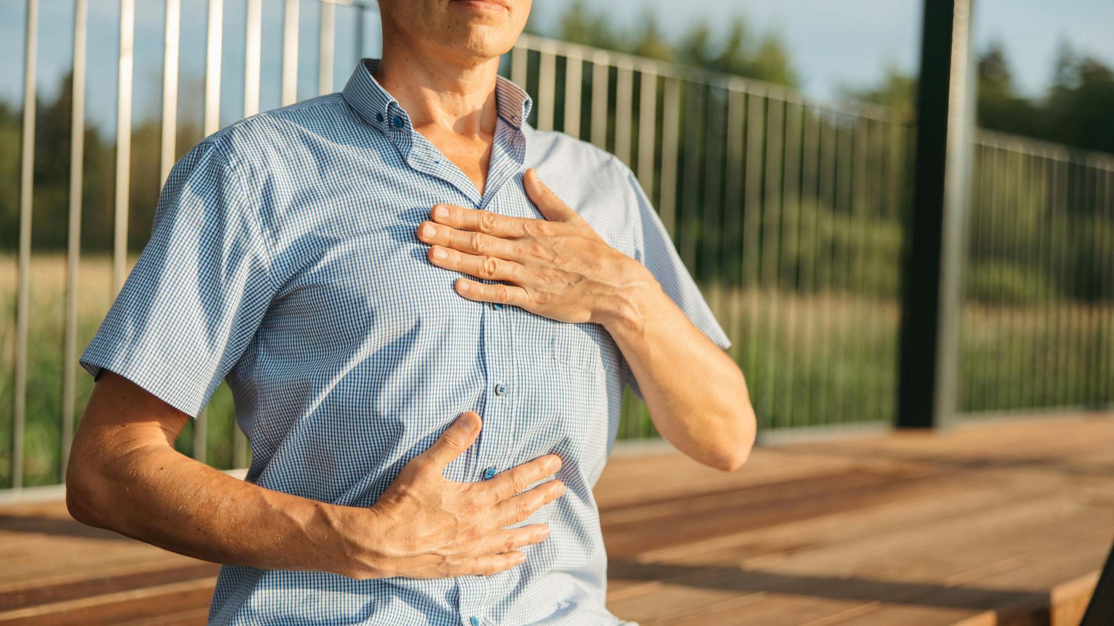 man practising breathwork with hands on chest and belly outdoors