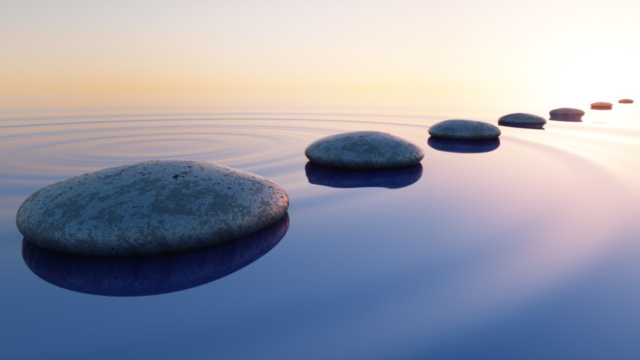 Row of stones in calm water in the wide ocean concept of meditation