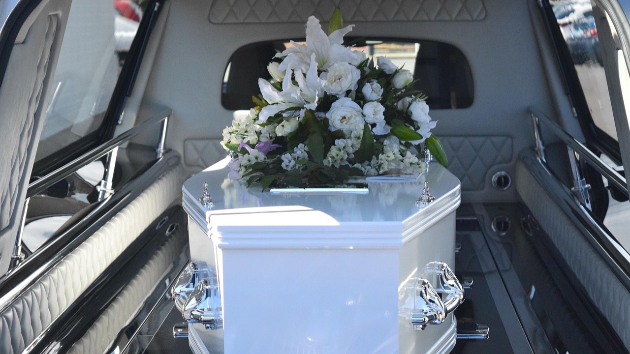 Coffin & flowers in the back of a hearse