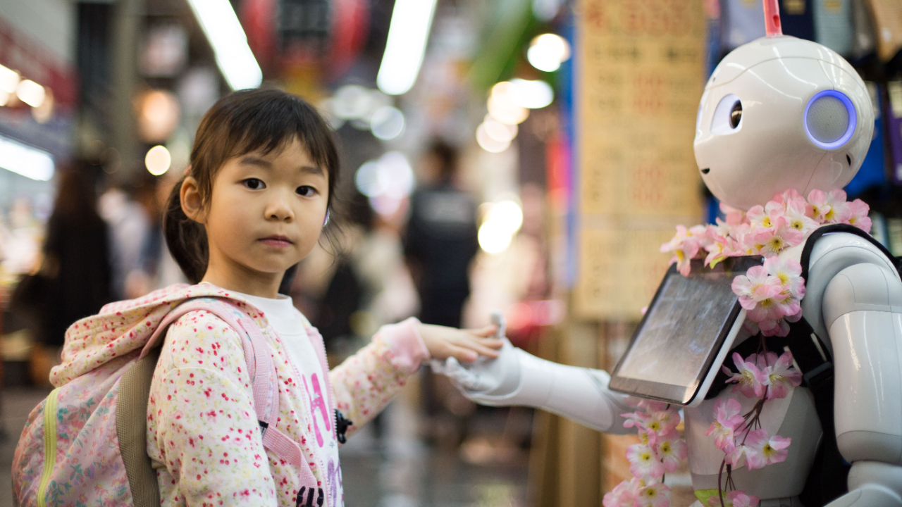 young person holds hands with a robot