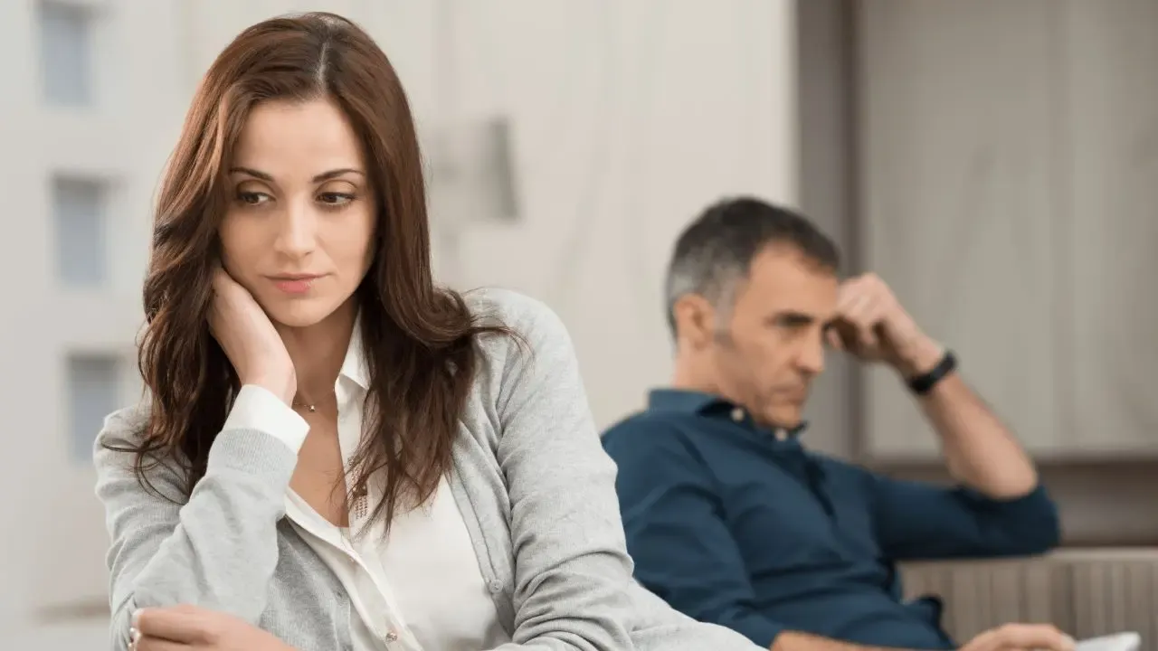 Couple on couch displaying love avoidant distancing behaviors avoiding connection