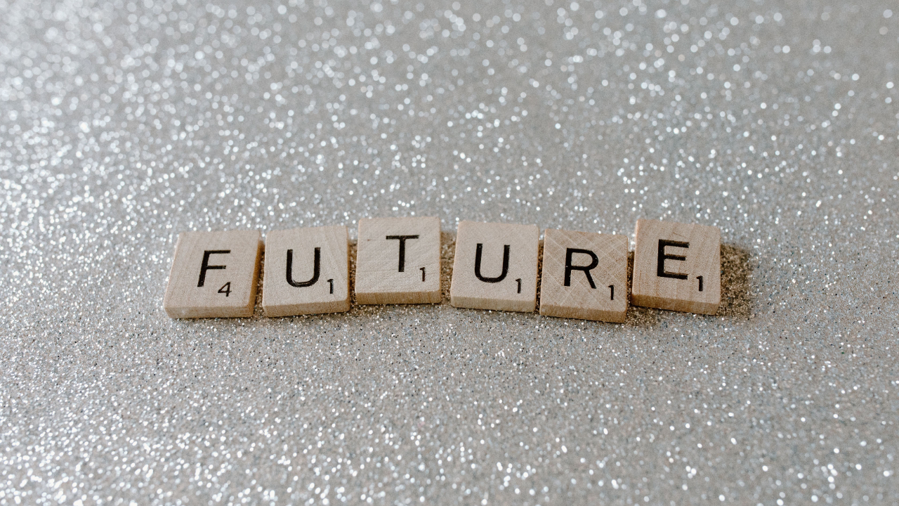 Scrabble tiles spelling "FUTURE" on a glittery silver surface.