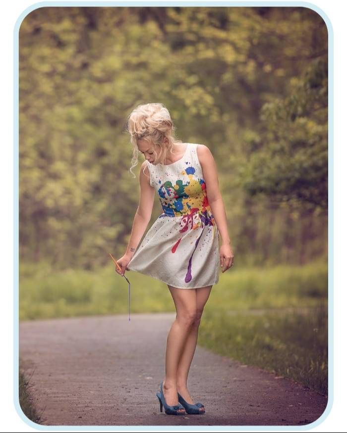 Tara Lesher in a paint-splattered dress creating on an outdoor path