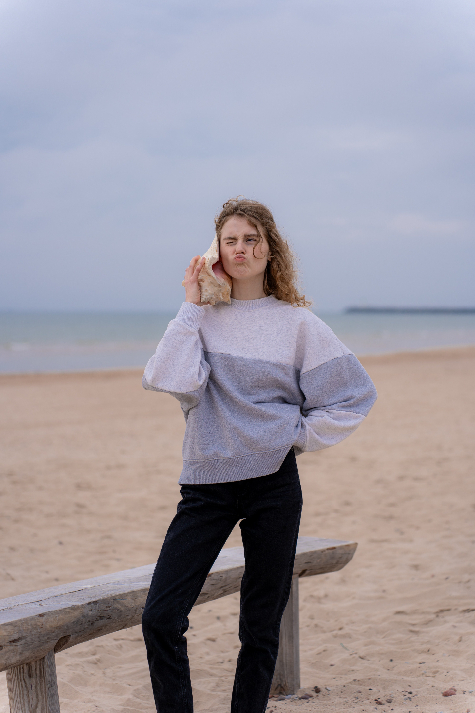 Girl holding a seashell up to her ear