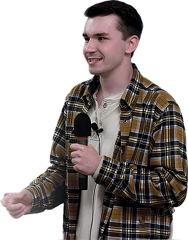 Autism keynote speaker Tyler McNamer holding a microphone while speaking at an event