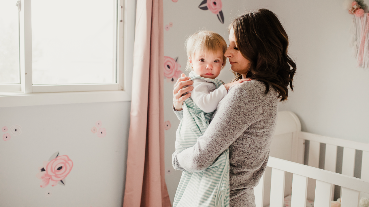 Mom rocking her baby to sleep in a nursery