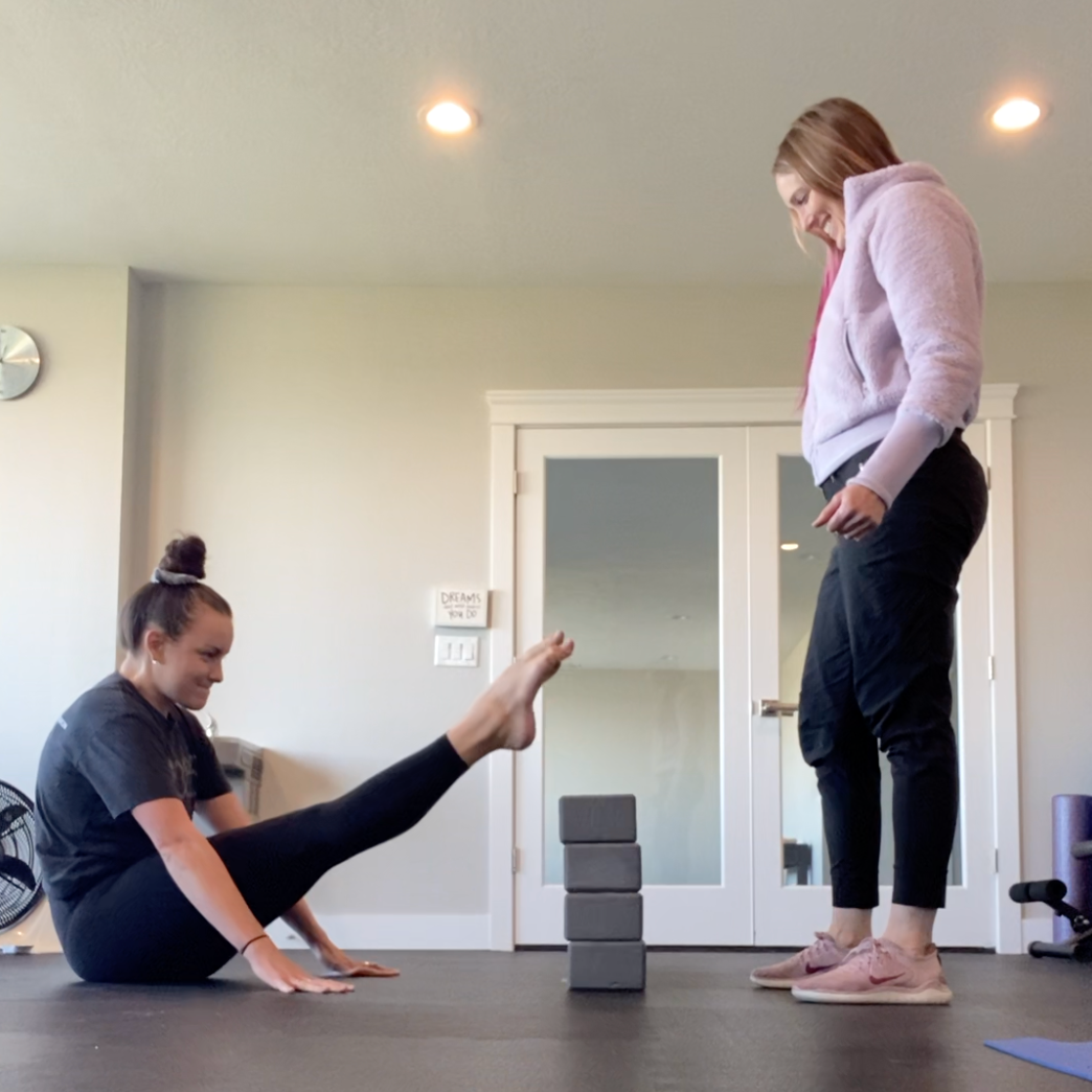 Amber coaching someone doing a handstand.