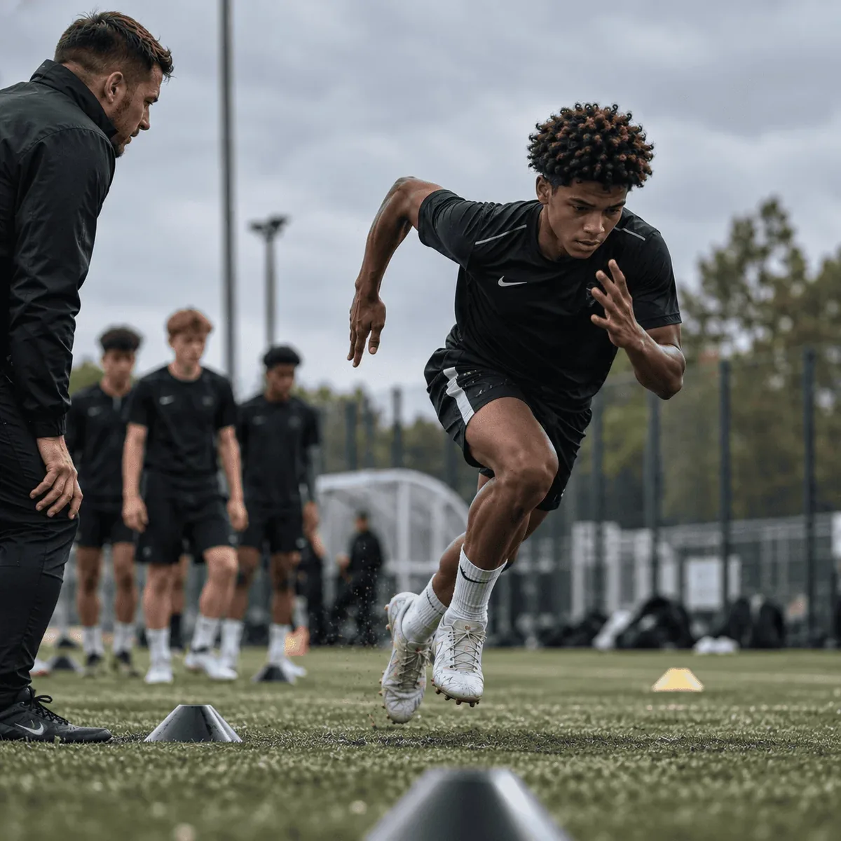 Coach watching a player sprint through a cone drill