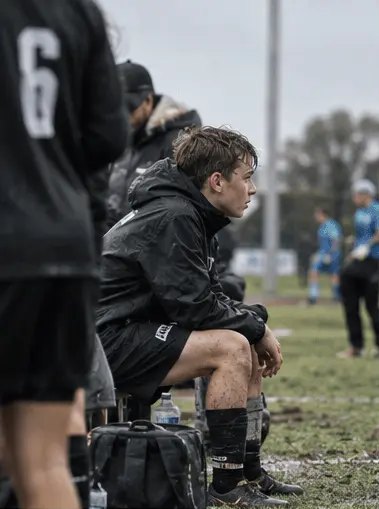 Young footballer waiting on the bench