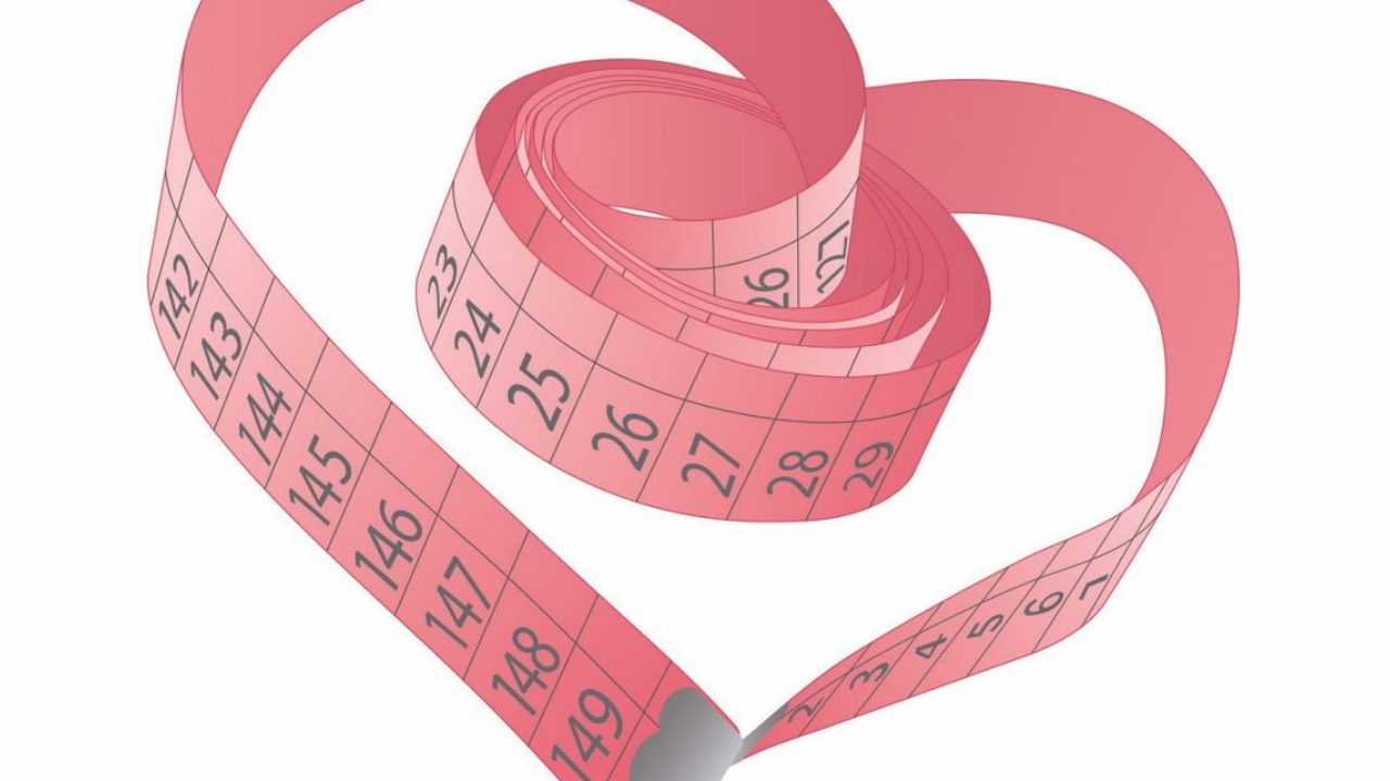 Pink dressmaker's measuring tape shaped into a heart, representing accurate wedding dress measurements, bridal alterations, and custom wedding gown fittings.