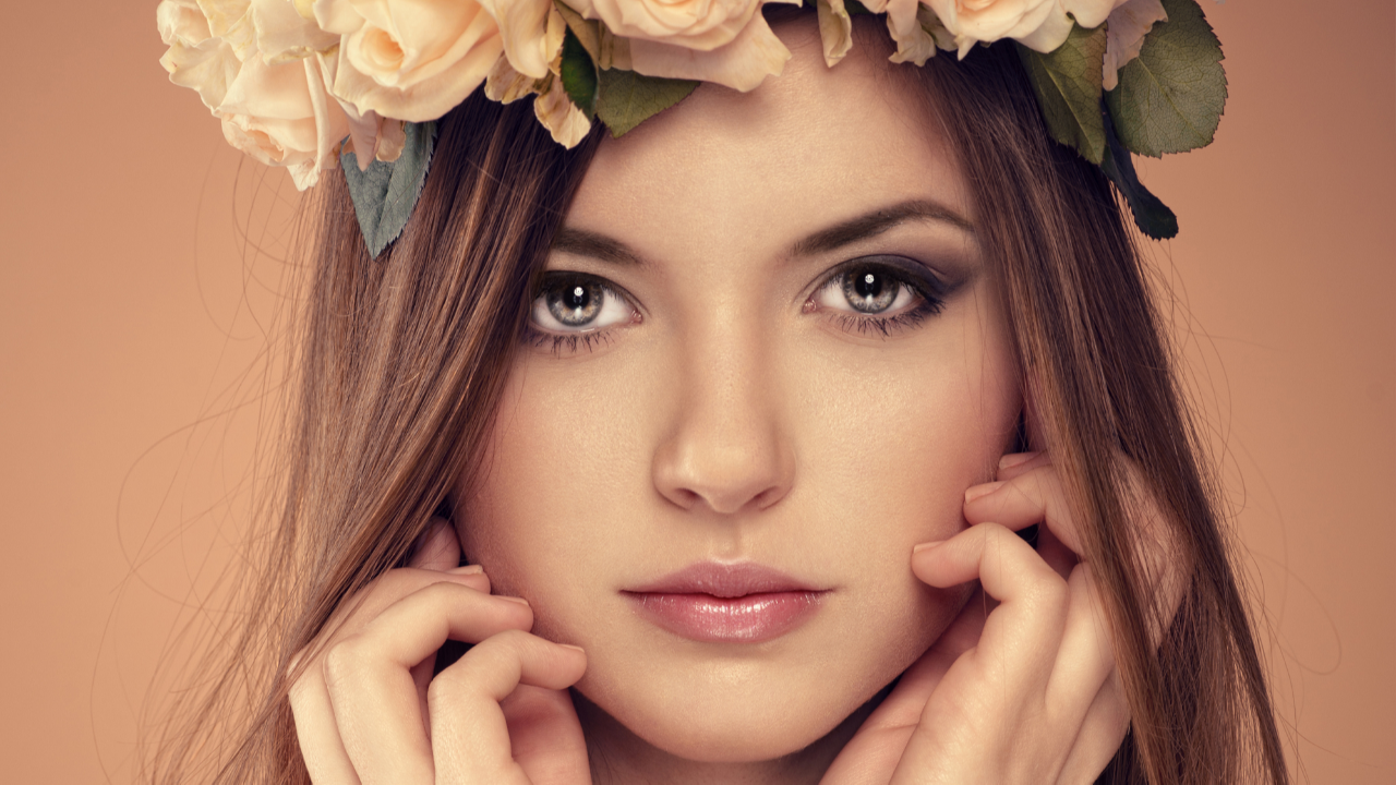 Bride with dramatic floral hairpiece, colorful makeup, and bright pink lipstick, representing personal style, creativity, and wedding dress personality.