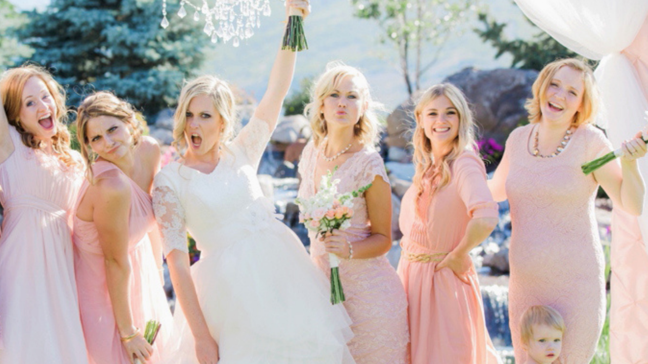 Bride and bridesmaids celebrating together outdoors during a bridal shower and wedding celebration surrounded by flowers and friends.