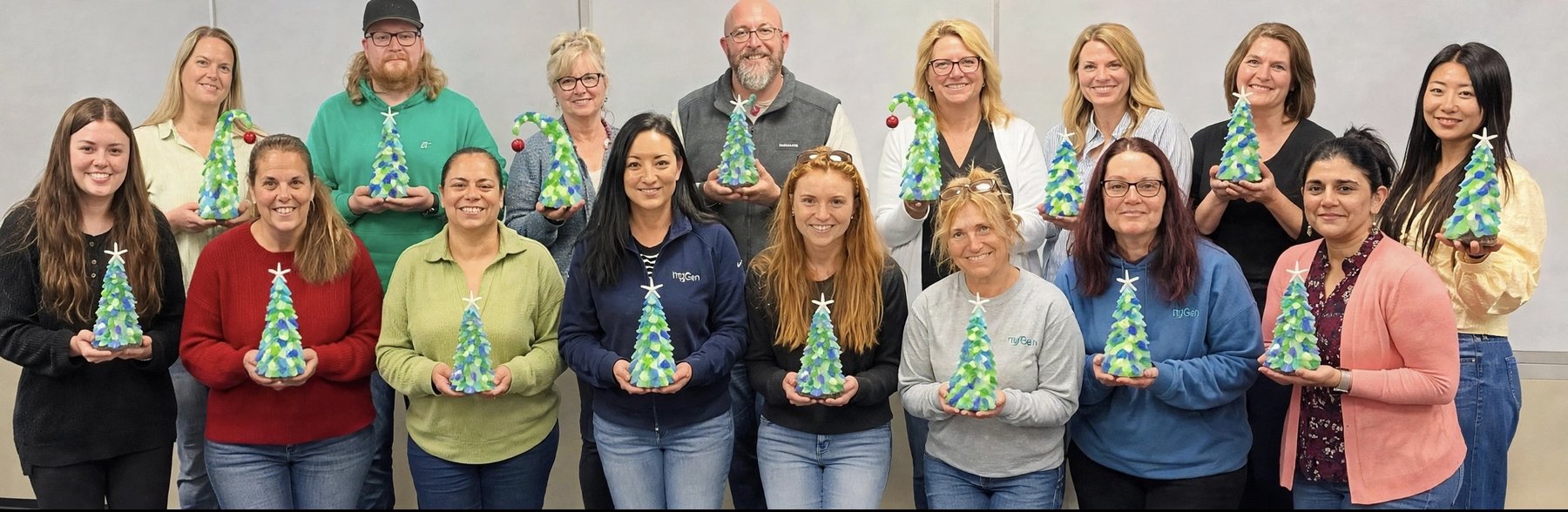A group holding the sea glass trees they each made at an Artist at Heart event in Cleveland
