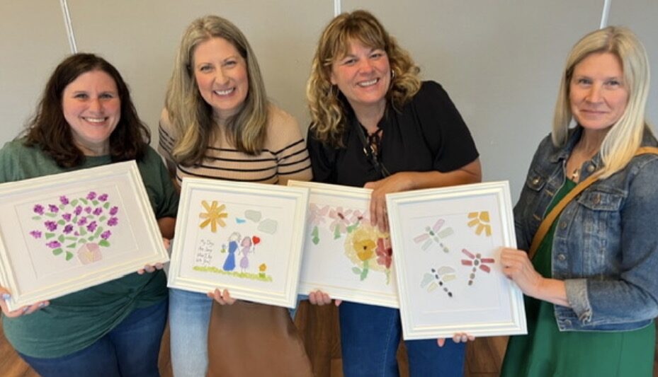 Adults holding framed beach glass collages they made at a Cleveland beach glass craft party