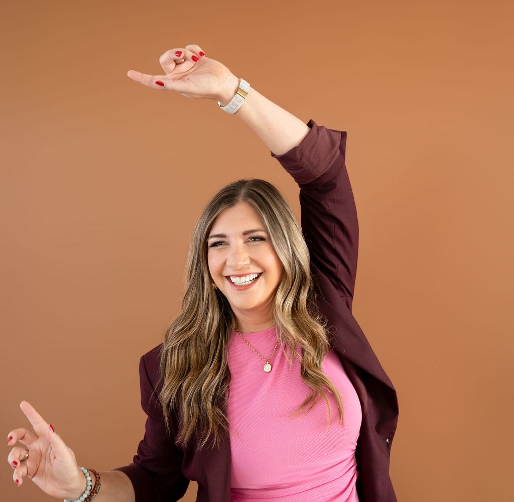 Holly Marie Haynes dancing and celebrating in a burgundy suit