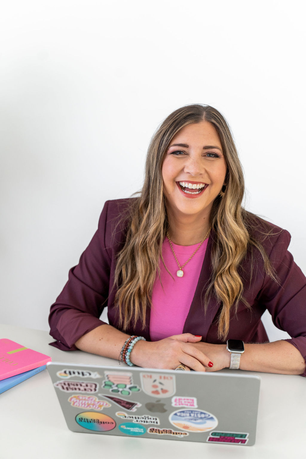 Holly Marie Haynes laughing at her desk with her laptop