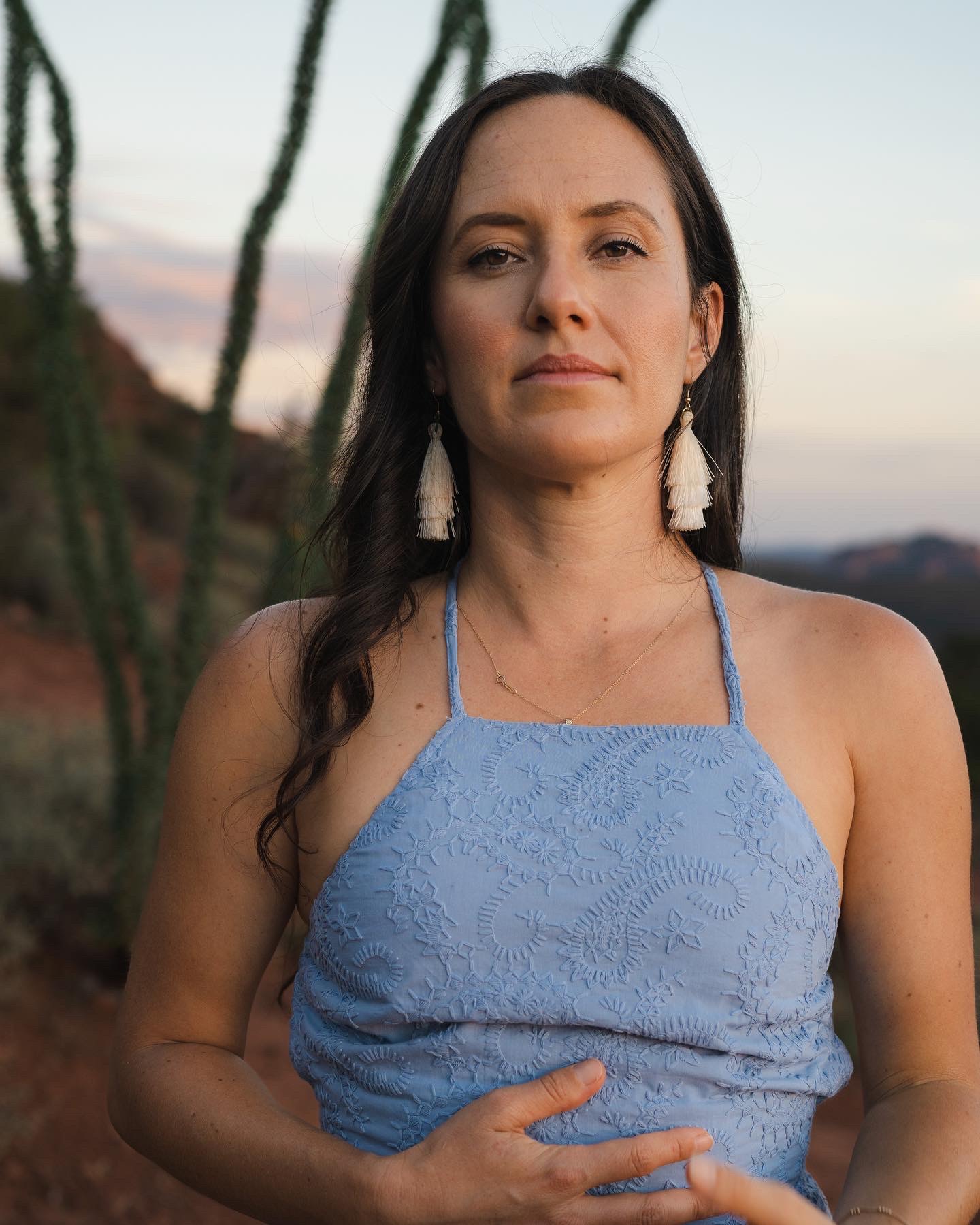 Leandra Rose standing in the Sedona desert at dusk, looking directly at the camera