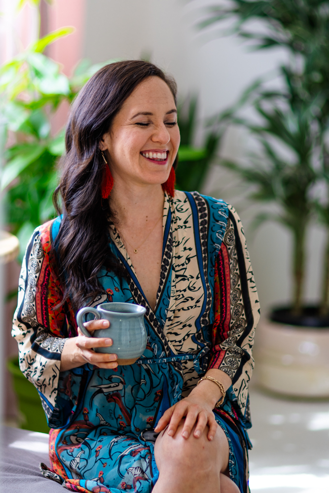 Leandra laughing with a mug of tea