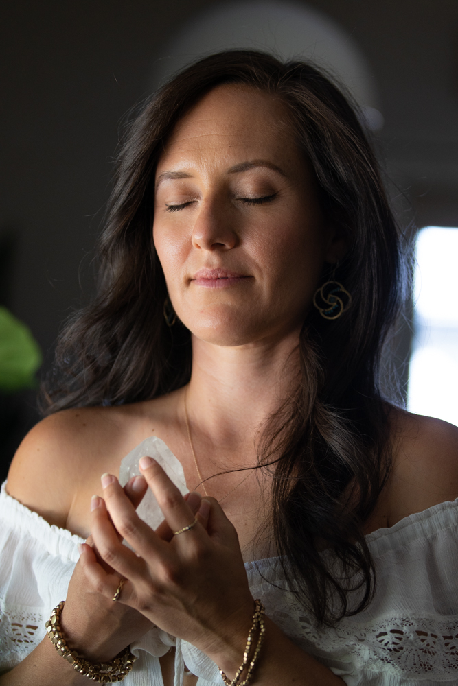 Leandra with eyes closed, calm, holding a crystal