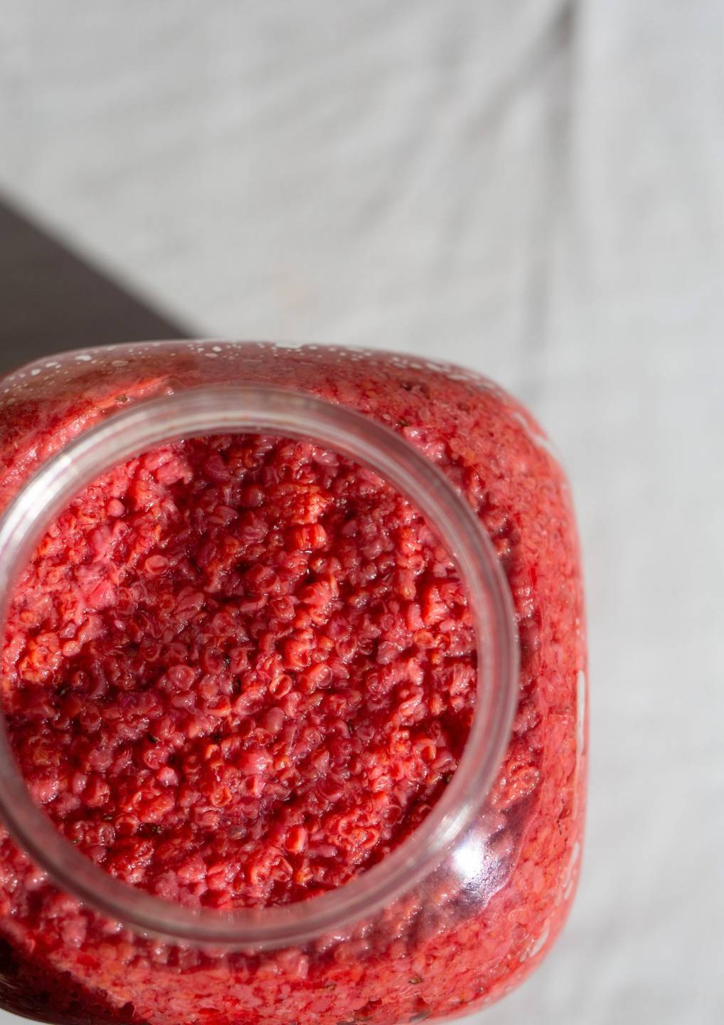 Glas mit roter Beeren-Fruchtmaische als Basis für wilden Essig