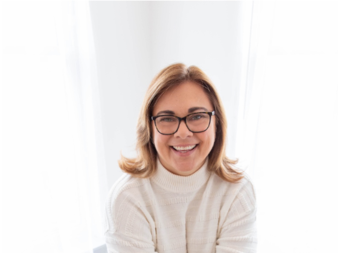 Beth smiling at her laptop, ready to welcome new Enneagram coaches